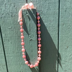 Pink beaded necklace with ribbon detail. Adjustable